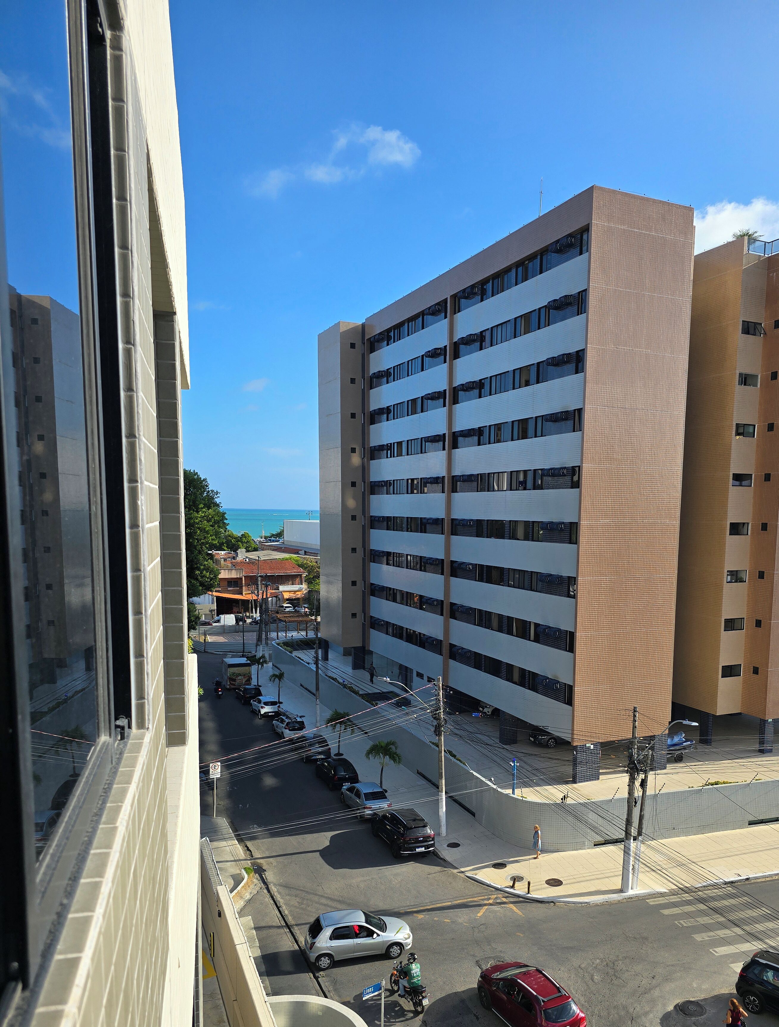 Un immeuble de grande hauteur, doté de nombreux étages et offrant une vue dégagée sur la rue.