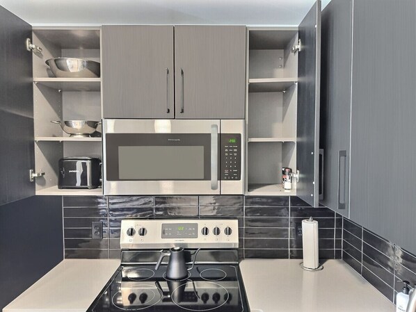 Una cocina moderna con microondas, horno y cocina a gas integrados.