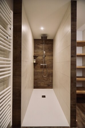 A modern shower with a wooden accent wall, a white floor, and a built-in shelf. - Chalet Le Criou - Morillon, Sleeps 12, Spa   (Morillon)