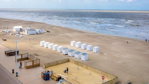 Ein Strand mit weißen Bauwerken und einem Holzdeck.
