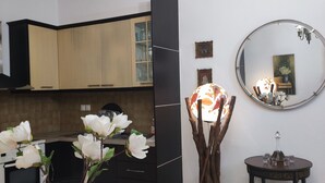 Una cocina moderna con armarios de madera, un comedor con una mesa redonda y un espejo en la pared.