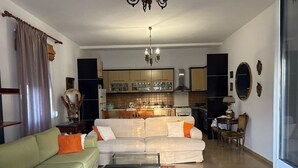 Una sala de estar con un sofá, una mesa de centro y un comedor con sillas y una mesa.