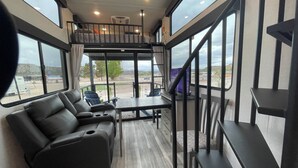 Un intérieur moderne avec un canapé, une table et un escalier menant à un niveau supérieur.