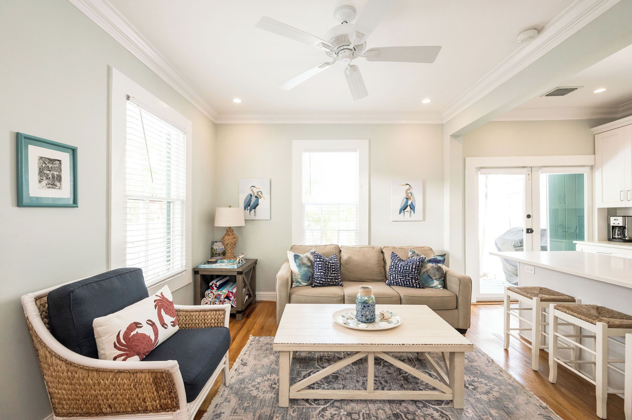 A living room with a sofa, coffee table, and a dining area with stools.