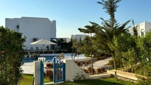 A residential area with a white building, a pool, and a blue gate.