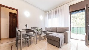Un salon moderne comprenant un canapé, une table à manger, des chaises et un balcon avec vue.