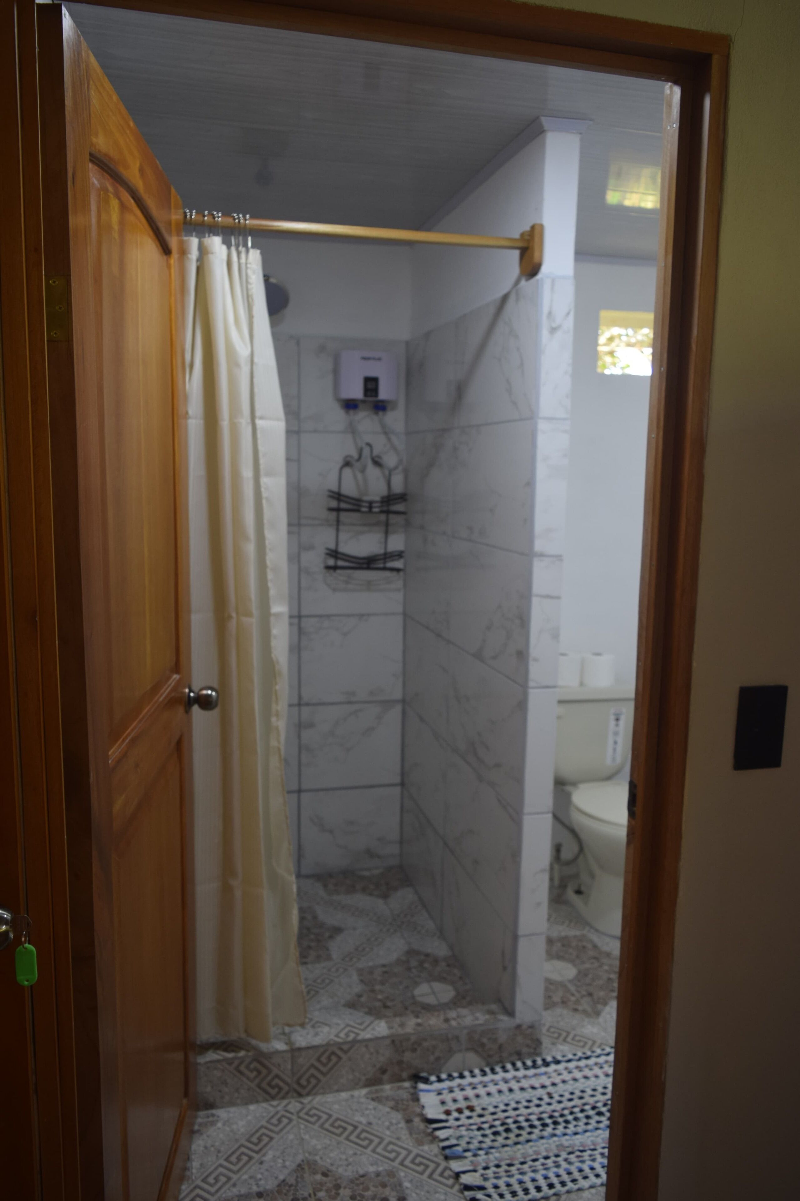 A bathroom with a shower, a toilet, and a sink.