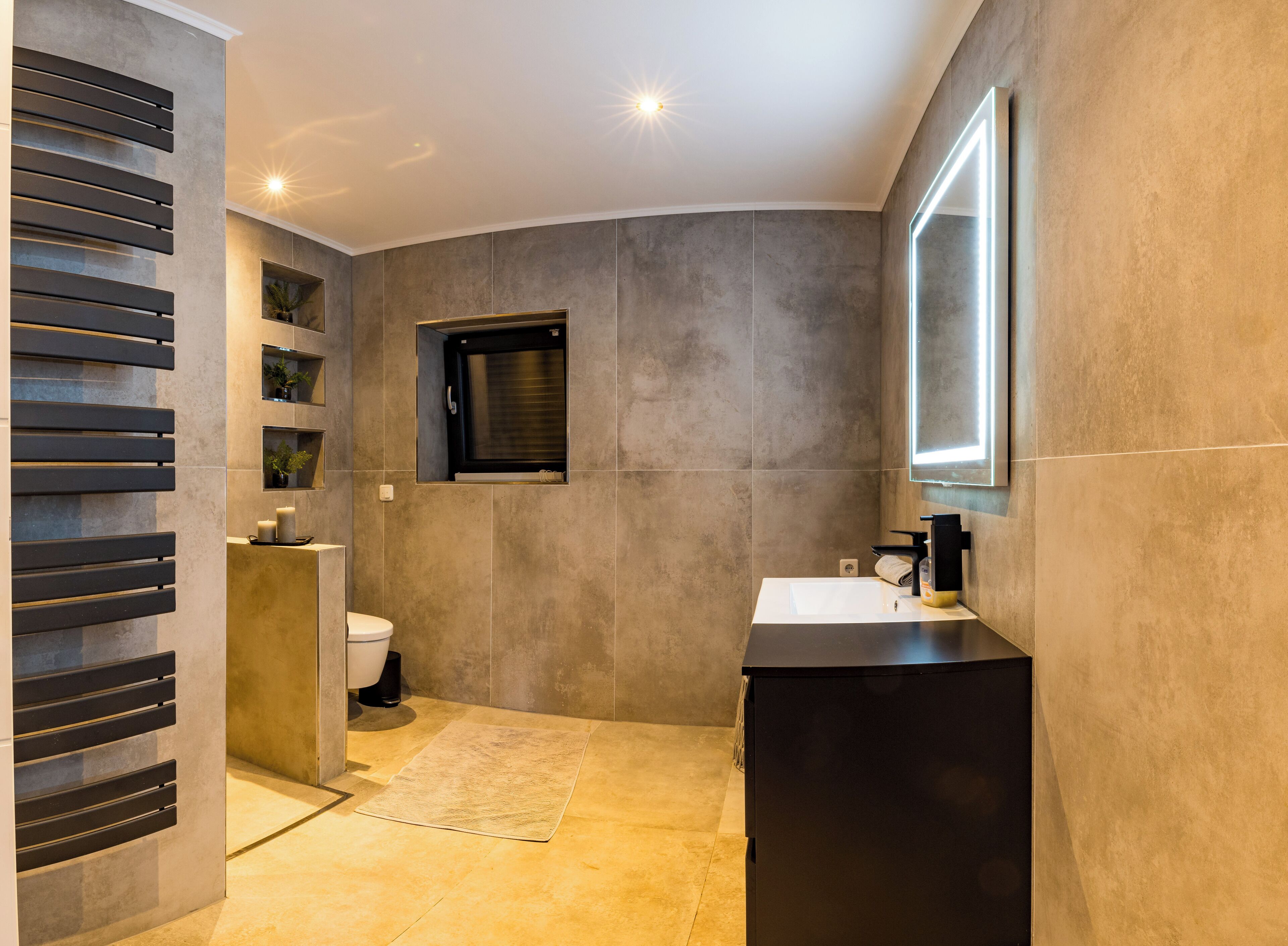A modern bathroom with a built-in shower, a toilet, a sink, and a mirror.