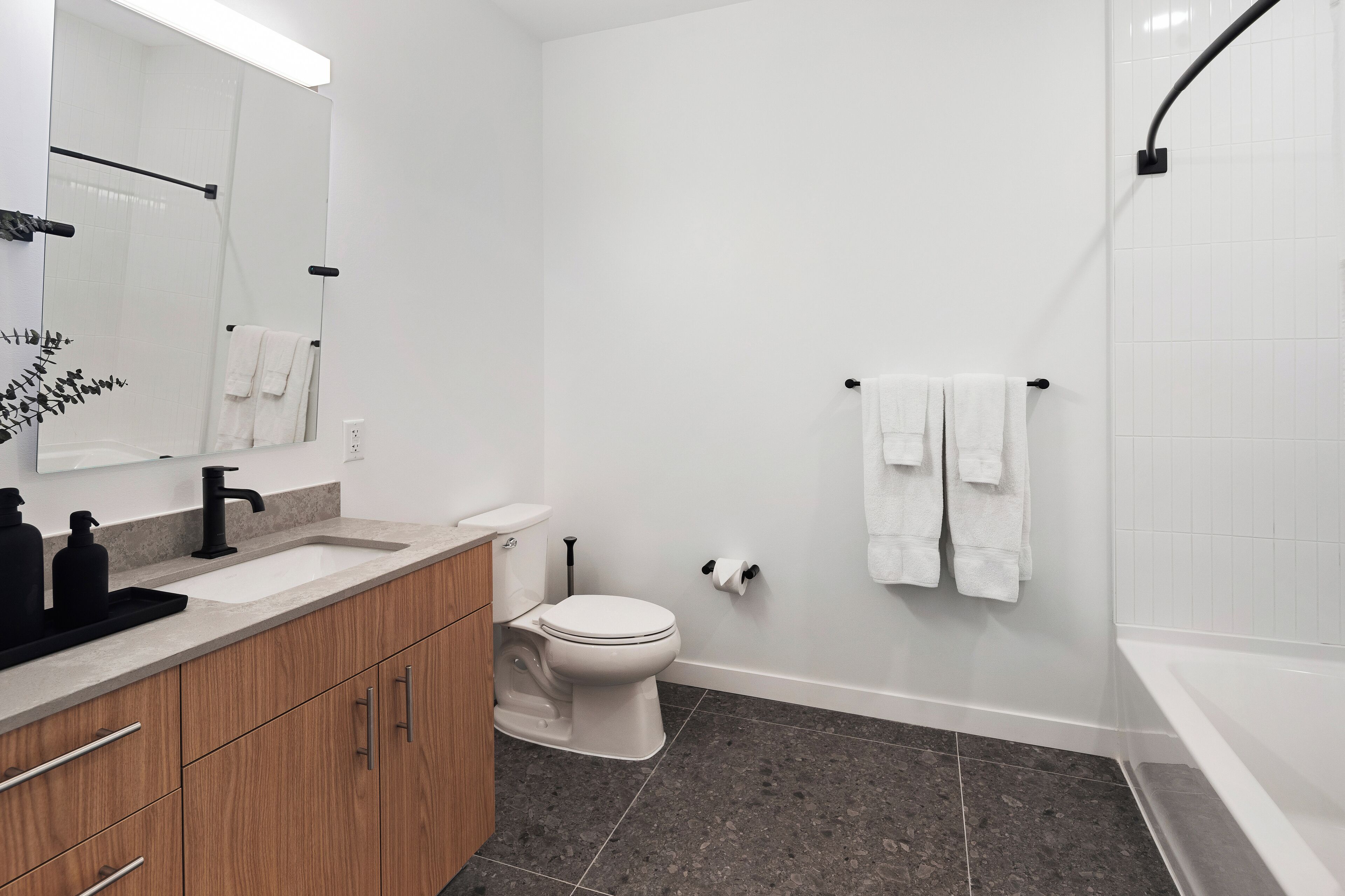 Une salle de bain moderne avec un lavabo, des toilettes et une baignoire, le tout de couleur blanche.