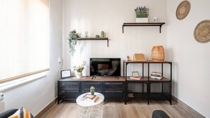 A modern living room with a TV, shelves, a small table, and a window. - Apartment in Sotrondio near the Nalon river (San Martin del Rey Aurelio)