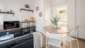 A living room with a TV, sofa, coffee table, and a dining area with chairs and a table. - Apartment in Sotrondio near the Nalon river (San Martin del Rey Aurelio)