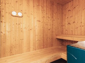 A wooden sauna room with benches and a wall-mounted thermometer. - 4 Star Holiday Home in Brovst (Brovst)