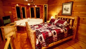 Een gezellig houten blokhut slaapkamer met een houten bed, een groot raam en een inbouwhaardbad.