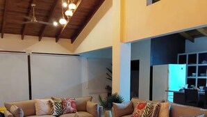 Un salón amplio con dos sofás, una mesa de centro y un ventilador de techo.
