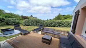 A patio area with wicker furniture, a table, and a grill. - Renovated, detached belle-illoise family home, 3 bedrooms, sleeps 9 (Le Palais)