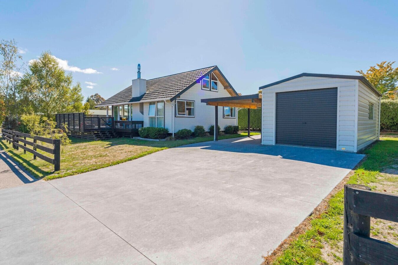 Ein modernes, zweistöckiges Haus mit Garage, überdachter Veranda und gepflegtem Rasen.
