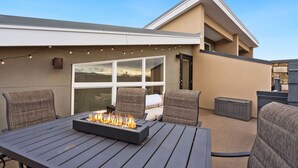 An outdoor patio with a fire feature, seating, and a view of the house. - Mountain View Getaway - Groups Welcome! (Fort Collins)