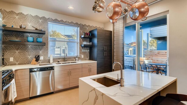 A modern kitchen with a central island, stainless steel appliances, and a view to the outdoors. - Mountain View Getaway - Groups Welcome! (Fort Collins)