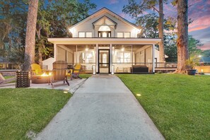 Une maison à deux étages dotée d’un porche abrité, de grandes fenêtres et d’une pelouse bien entretenue.