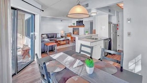 A modern kitchen with a central island, a dining area with a glass table, and a living space with a sofa and coffee table. - Big Boulder Relaxation, Slopes Up, Big Boulder, Jack Frost Ski Resorts  (Lake Harmony)