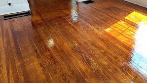 Una habitación con suelo de madera, una pared de madera y un ventanal.