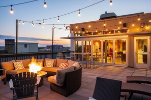 A rooftop terrace with outdoor seating, a fire feature, and string lights. - DT 2BD Steps from Target Field Gym Kitchen Laundry (Minneapolis)