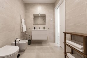 Une salle de bain moderne équipée de toilettes, d’un bidet et d’un lavabo.