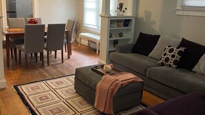 A living room with a gray sofa, a purple armchair, a patterned rug, and a ceiling fan. - Charming 2-bedroom house in busy downtown Indianapolis with WiFi, AC. (Indianapolis)