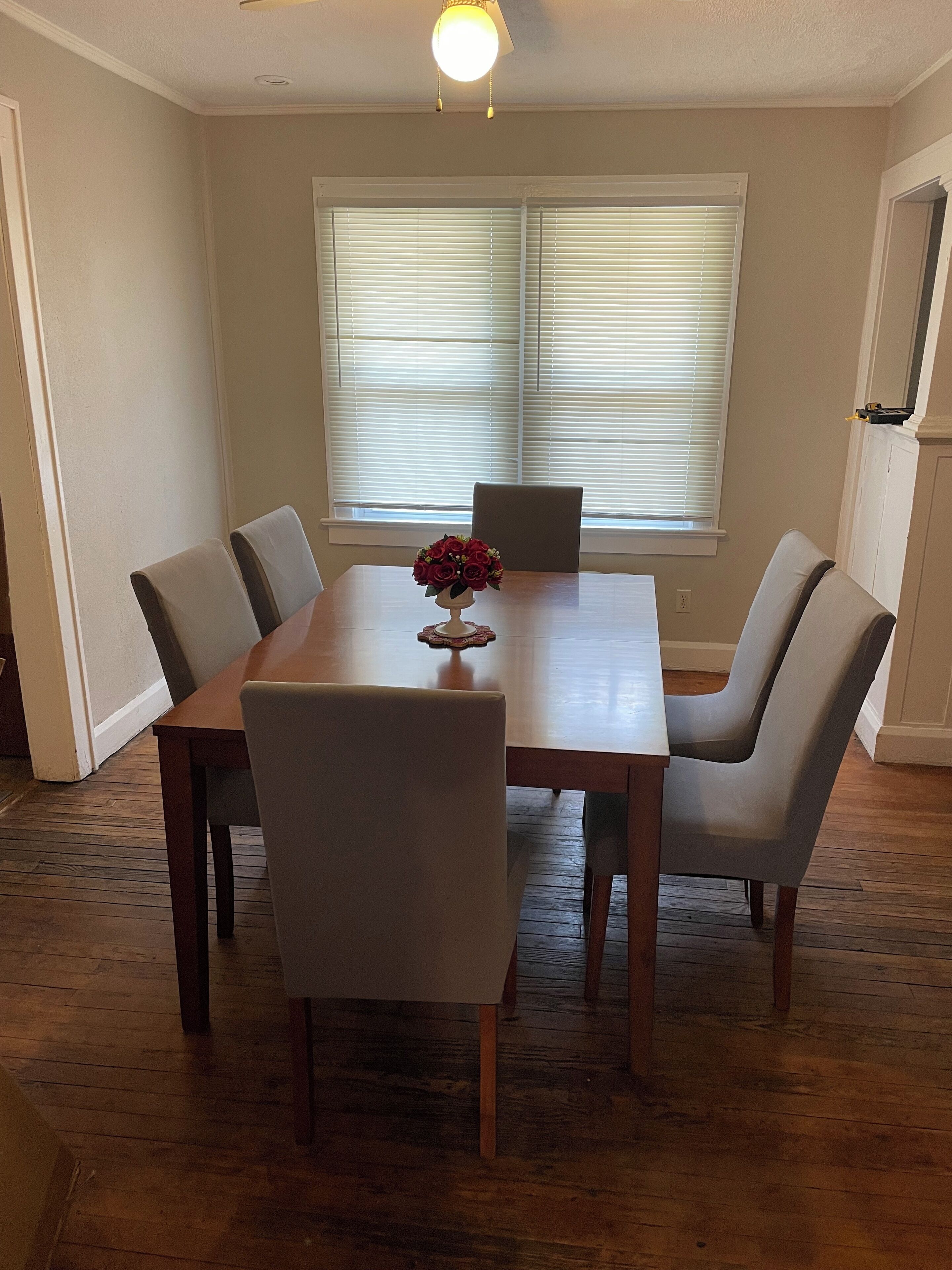 A dining room with a wooden table and six chairs.