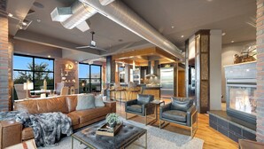 A spacious living area with leather sofas, a coffee table, and a fireplace. - Penthouse With Mountain Views in Heart of Old Town (Fort Collins)