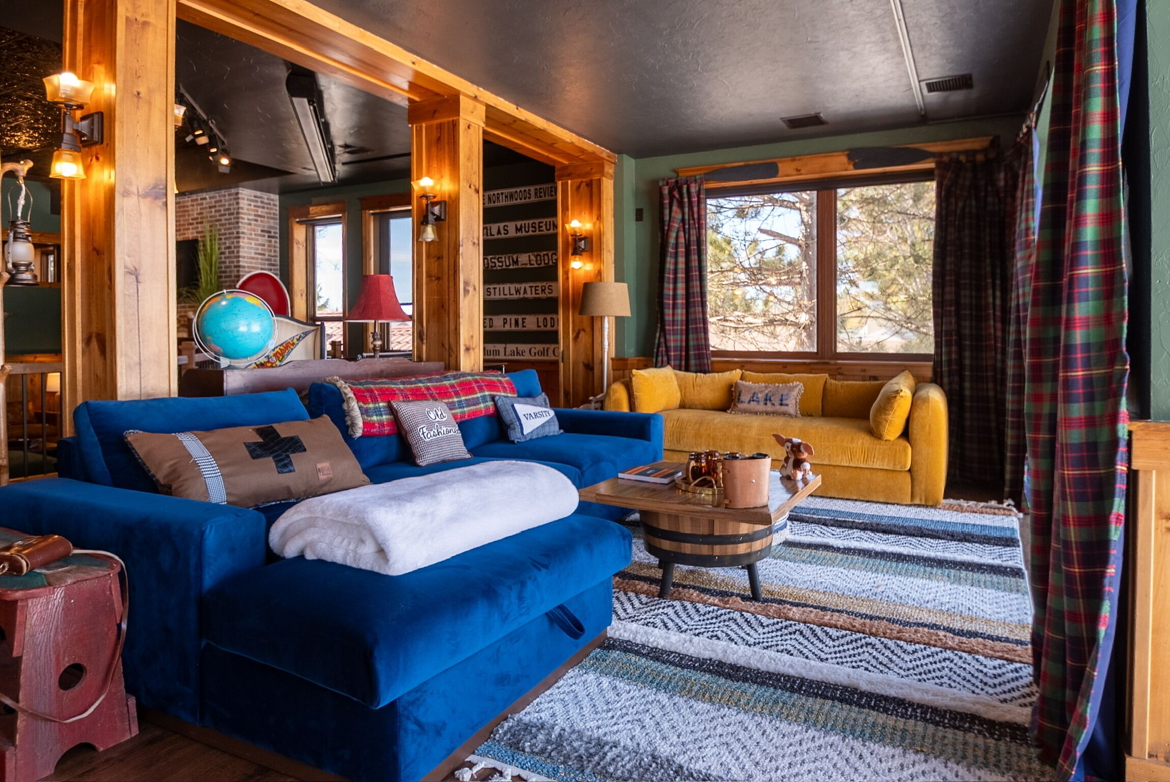 Una sala de estar acogedora con un sofá azul, un sillón amarillo y una mesa de centro de madera.