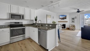 A modern kitchen with white cabinetry, stainless steel appliances, and a granite countertop. - Boardwalk to Beach ready! Boat Slip & Parking. (Ocean City)