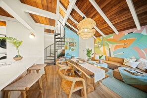 Une cuisine moderne avec un plan de travail blanc, des tabourets en bois et une table à manger en bois.
