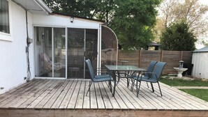 A wooden deck with a glass door leading to a patio area. - Winnipeg spotless Cozy 3 bedrooms home (Winnipeg)