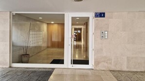 Ein Hotel Eingang mit Glastür, einer Zimmerpflanze und einem Schild mit der Nummer 4.47.