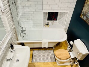 Un bany amb una banyera blanca, un lavabo i un vàter.