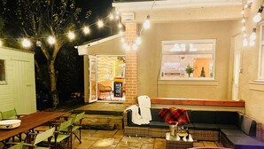 Eine Terrasse im Freien mit Esstisch, Stühlen, einer Couch und einem Whirlpool.