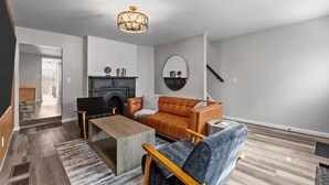 A modern living room with a fireplace, a sofa, a coffee table, and a mirror on the wall.