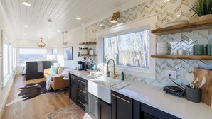 Una cocina moderna con un ventanal grande, techo de madera y vistas al exterior.