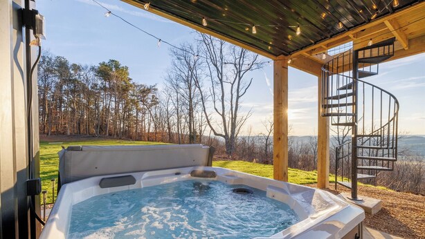 Un jacuzzi con vistas a un bosque y montañas.