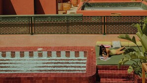 A rooftop terrace with a pool, a green outdoor seating area, and a view of the cityscape. - The Mellah Hotel (Marrakech)