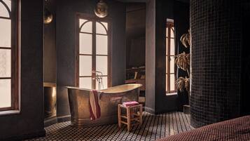 A bathroom with a bathtub, a wooden stool, and a large window.
