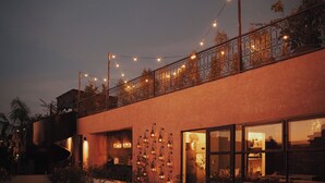 A modern building with a spiral staircase, large windows, and string lights. - The Mellah Hotel (Marrakech)