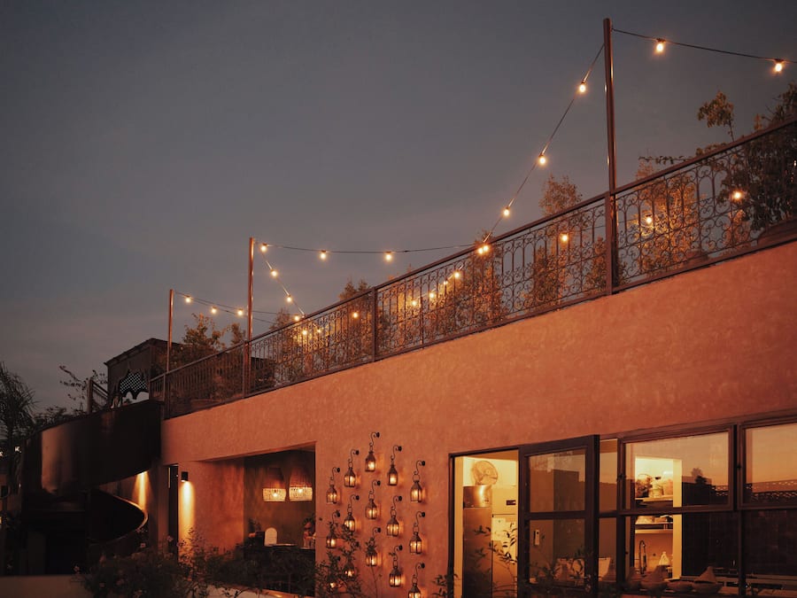 A modern building with a spiral staircase, large windows, and string lights.