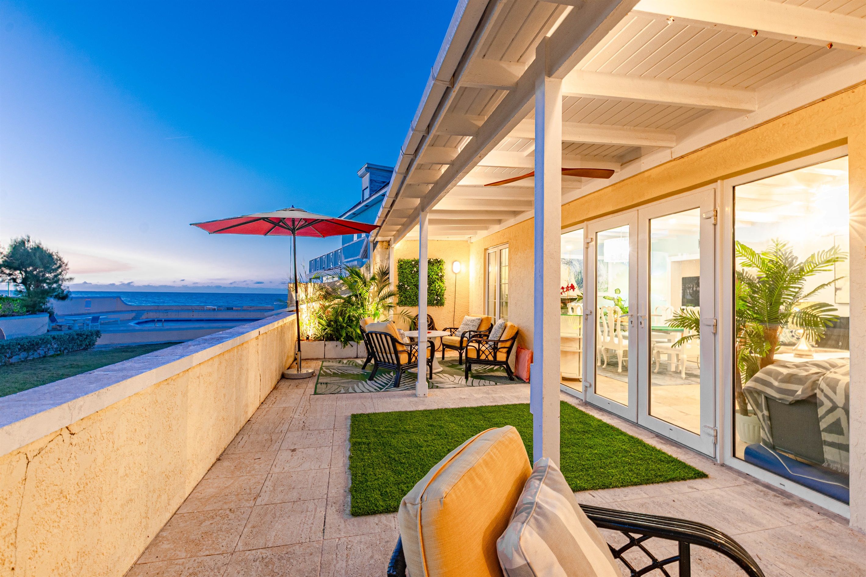 Un espace extérieur abrité, doté d’une terrasse, de sièges et offrant une vue sur la mer.