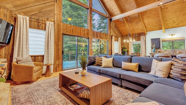 A spacious living room with a large sofa, a coffee table, and a television.