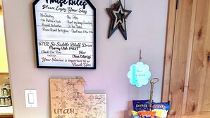 A hotel reception area with a neon 'Welcome' sign, a 'House Rules' sign, a map of Utah, and a snack cart. - Charming 2-bedroom bacement with WiFi, AC in enjoyable Murray (Murray)