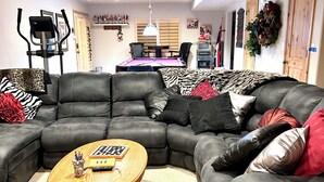 A living room with a sectional sofa, a round coffee table, and a pool table. - Charming 2-bedroom bacement with WiFi, AC in enjoyable Murray (Murray)