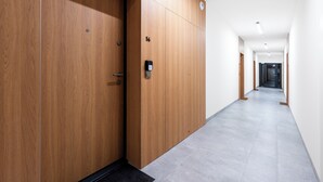 Un pasillo moderno con puertas de madera y cerradura digital.