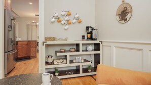A modern kitchen with a built-in coffee station, a coffee machine, and a shelf with tea and coffee mugs. - Cozy Colors Hideaway (Saint Joseph)